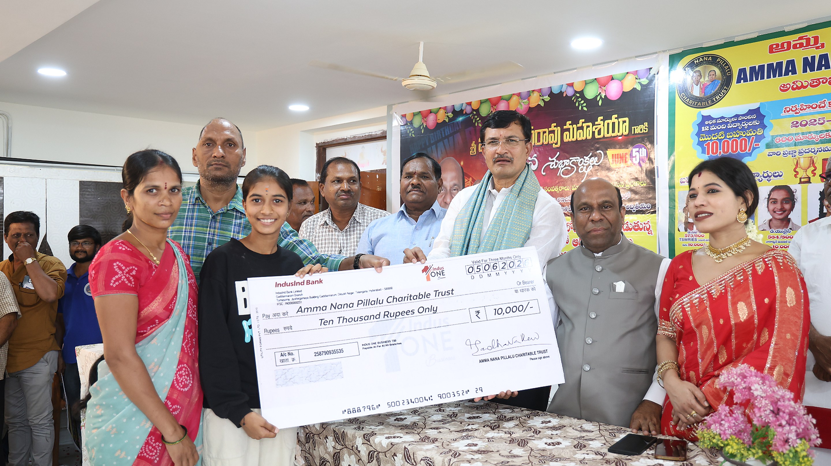 A student being awarded a ₹10,000 merit scholarship cheque