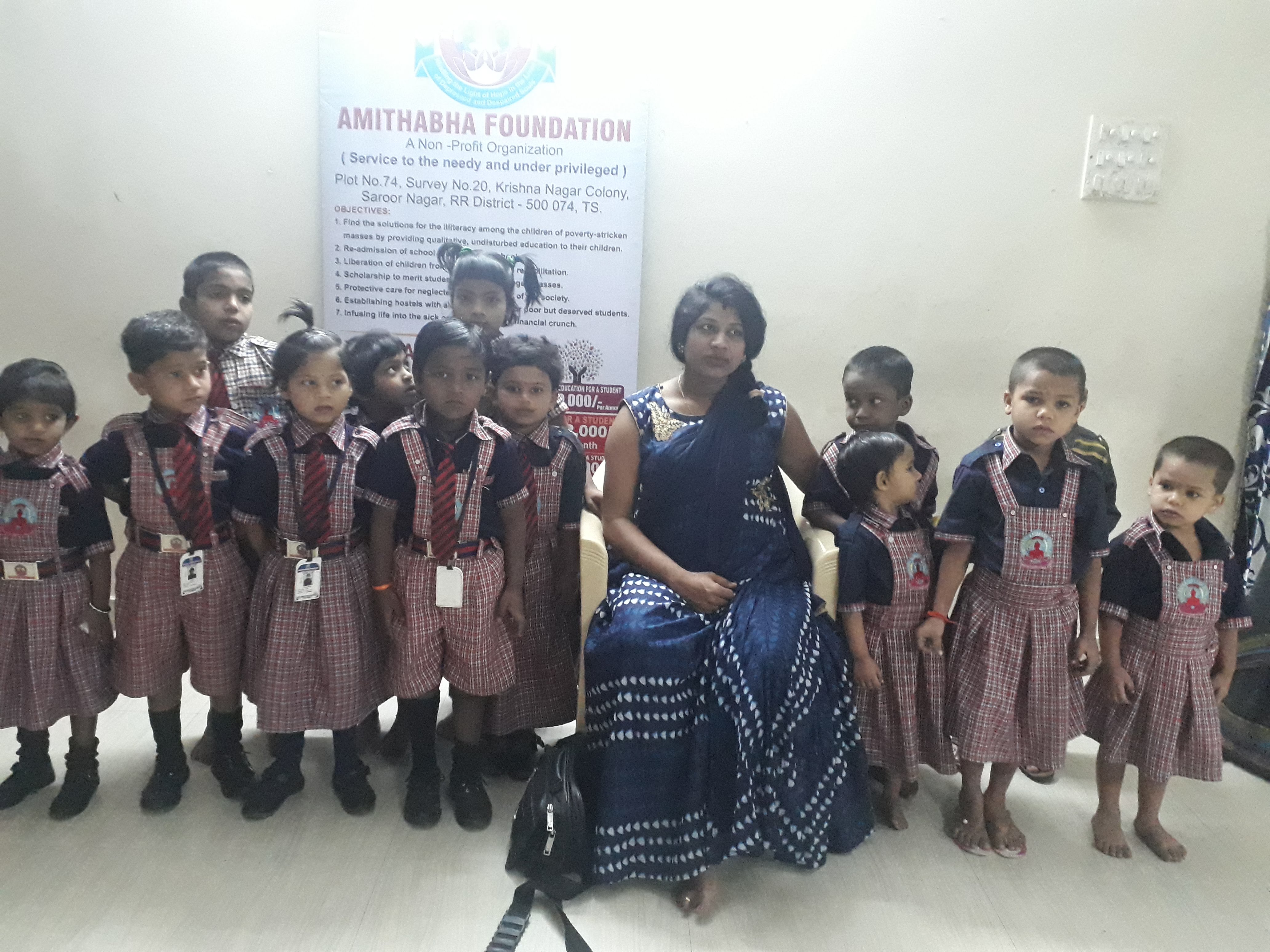 Young students of the Foundation with a teacher beside the Amithabha Foundation banner